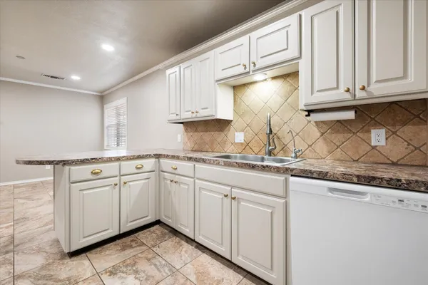 a kitchen with granite countertop white cabinets and sink