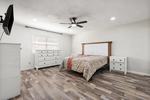 a bedroom with a bed and a tv on the dresser