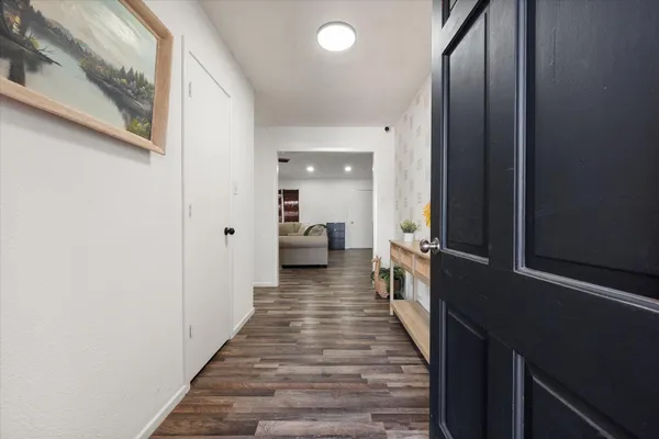 a view of a hallway with wooden floor and staircase