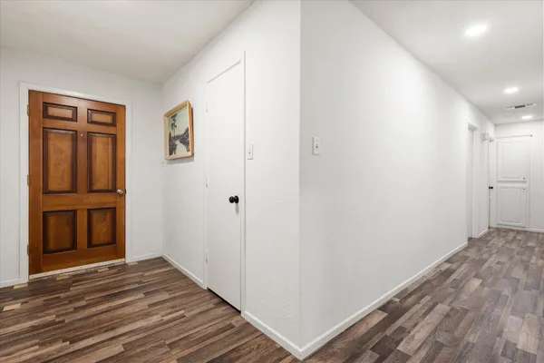 a view of a hallway with wooden floor