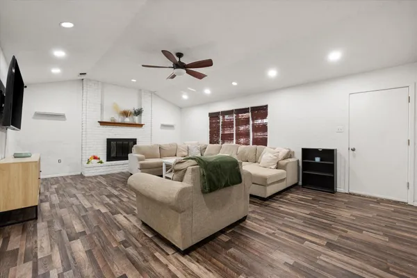 a living room with furniture a fireplace and a flat screen tv