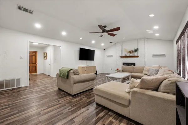 a living room with furniture and a wooden floor