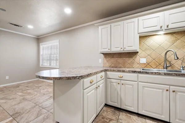 a kitchen with granite countertop white cabinets and sink