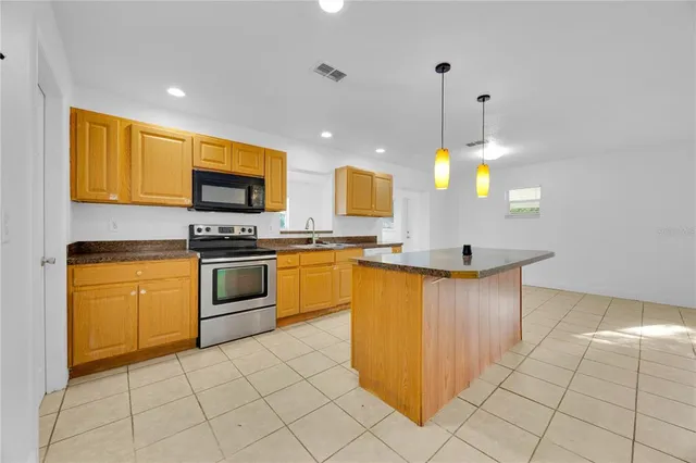 a kitchen with stainless steel appliances granite countertop a stove a sink and a refrigerator