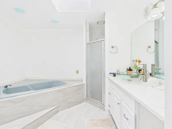 a bathroom with a bathtub sink and mirror