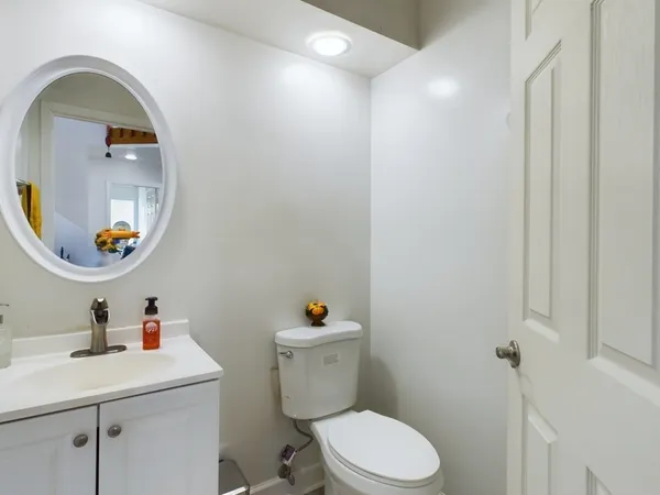 a bathroom with a toilet a sink and mirror