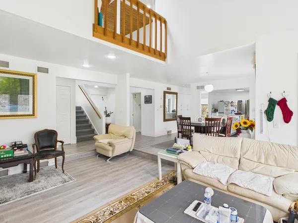 a living room with furniture and a wooden floor