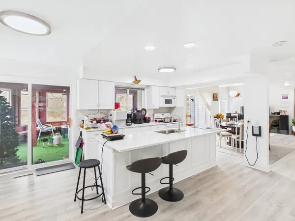 a view of a dining room kitchen and hall with wooden floor