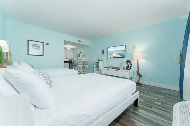 a bedroom with a bed and wooden floor