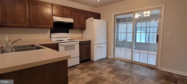 a kitchen with a refrigerator sink and cabinets