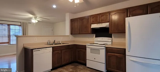 a kitchen with a sink a stove a refrigerator and cabinets