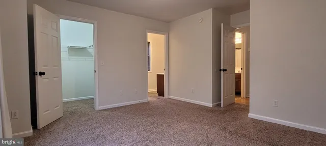 an empty room with closet and mirror