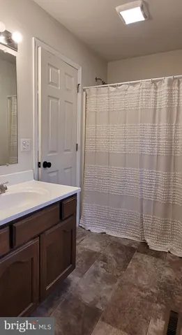 a bathroom with a shower sink and vanity