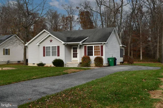 a front view of a house with a yard and trees