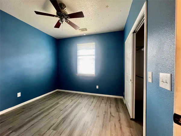 a view of a big room with windows and ceiling fan