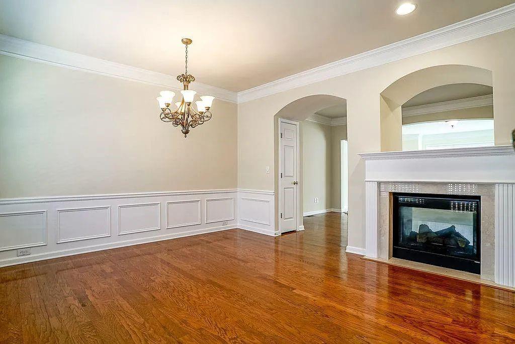 6120 Joybrook Road Duluth, GA 30097 - Photo 9 of 30 a view of an empty room with wooden floor fireplace and a window