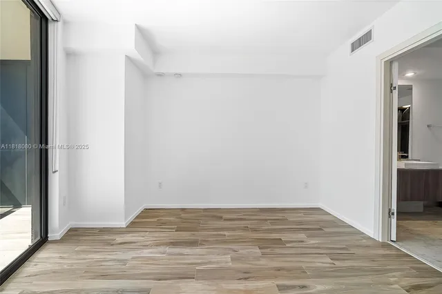 an empty room with wooden floor and door