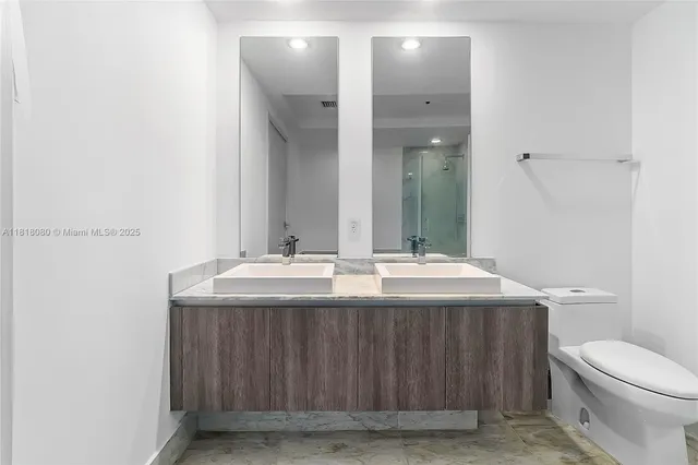 a bathroom with a toilet a sink and mirror