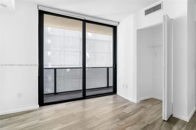 a view of a hallway with wooden floor and entryway
