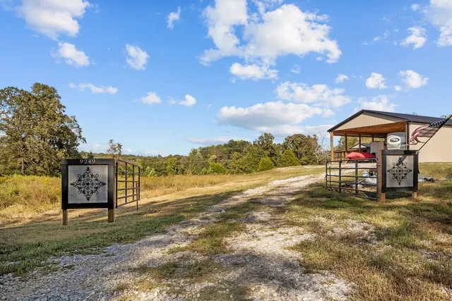 a view of a lake with table and chairs under an umbrella