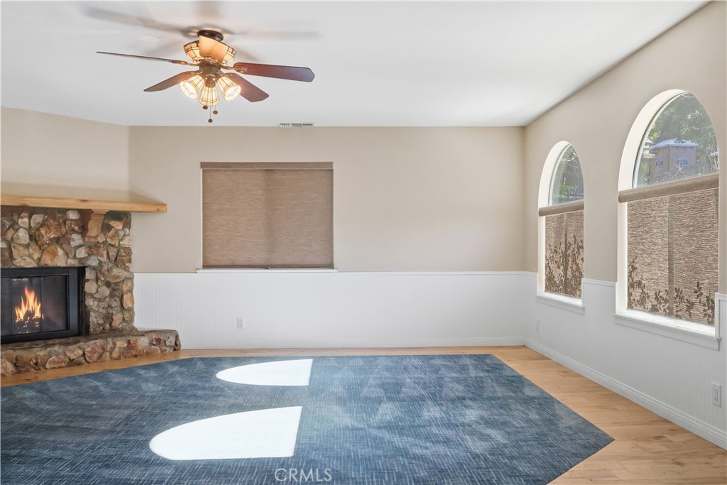 174 Golf Course Road Lake Arrowhead, CA 92391 - Photo 3 of 71 a view of a livingroom with a fireplace a ceiling fan and windows