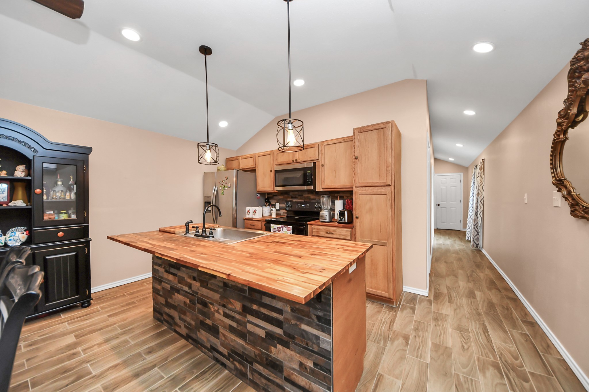 14961 Lamar Road Willis, TX 77378 - Photo 11 of 31 Kitchen with large breakfast bar, wood-style countertops, and open layout.