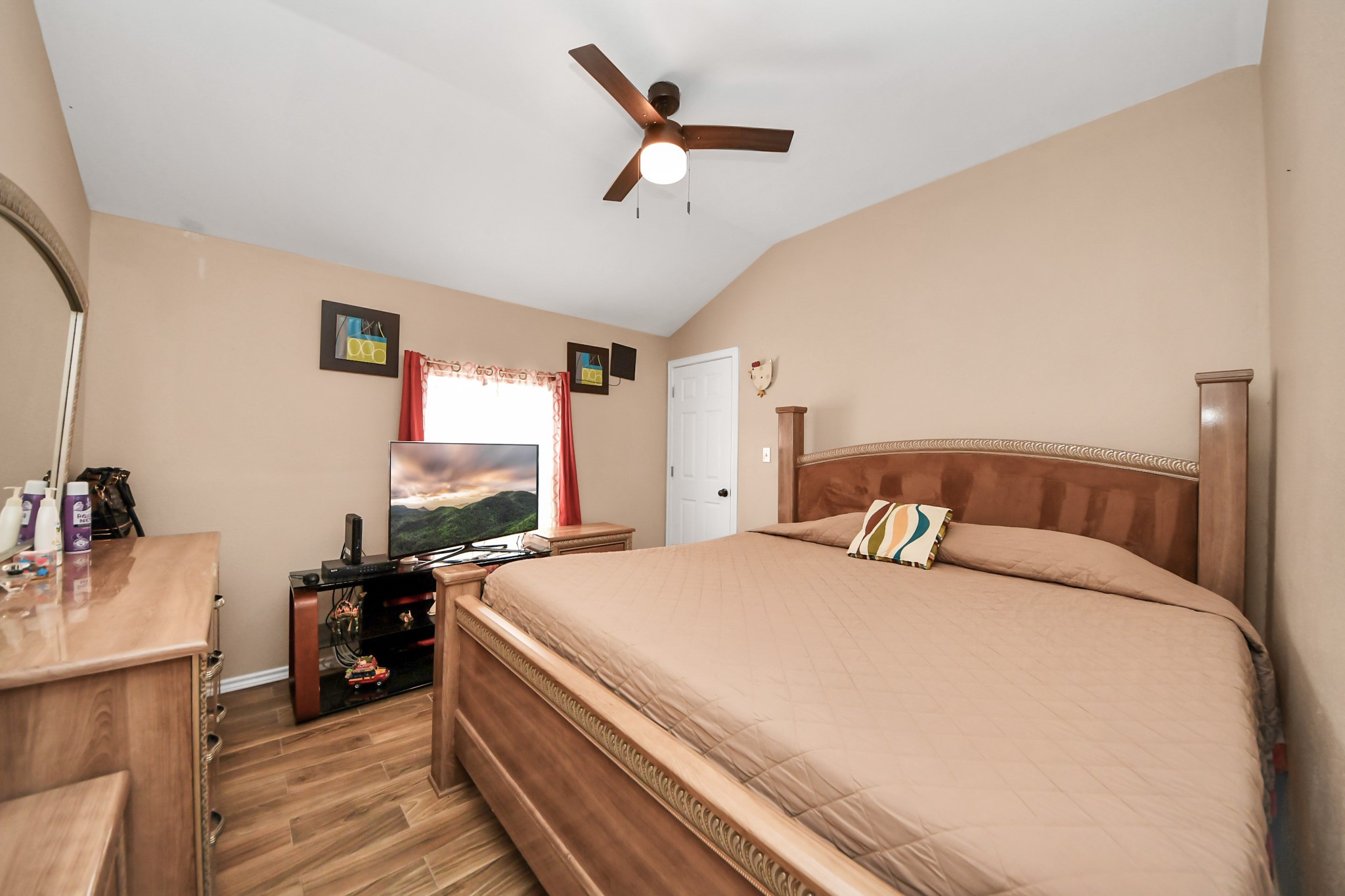 14961 Lamar Road Willis, TX 77378 - Photo 18 of 31 Spacious primary bedroom with vaulted ceiling and wood-look flooring.