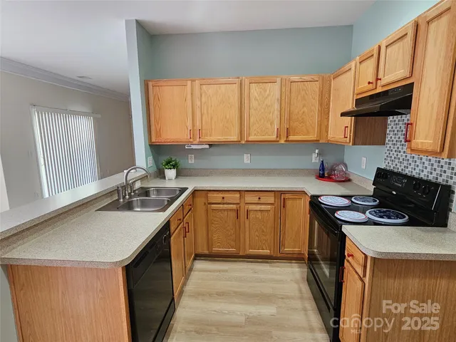 a kitchen with stainless steel appliances granite countertop a sink stove and cabinets