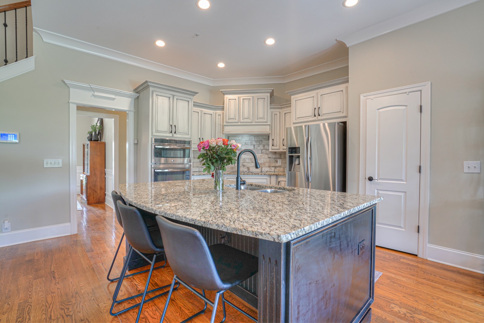 9620 Mona Road Murfreesboro, TN 37129 - Photo 22 of 58 a kitchen with stainless steel appliances granite countertop a kitchen island a stove a refrigerator a dining table and chairs with wooden floor