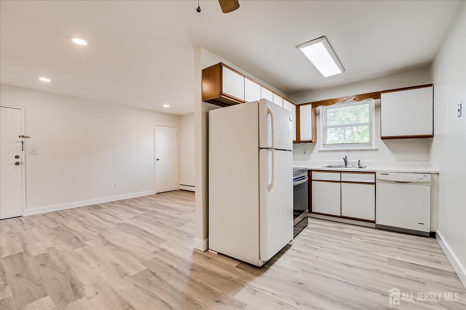 289 Main Street, Unit 4P Spotswood, NJ 08884 - Photo 11 of 22 a kitchen with a refrigerator a sink and cabinets