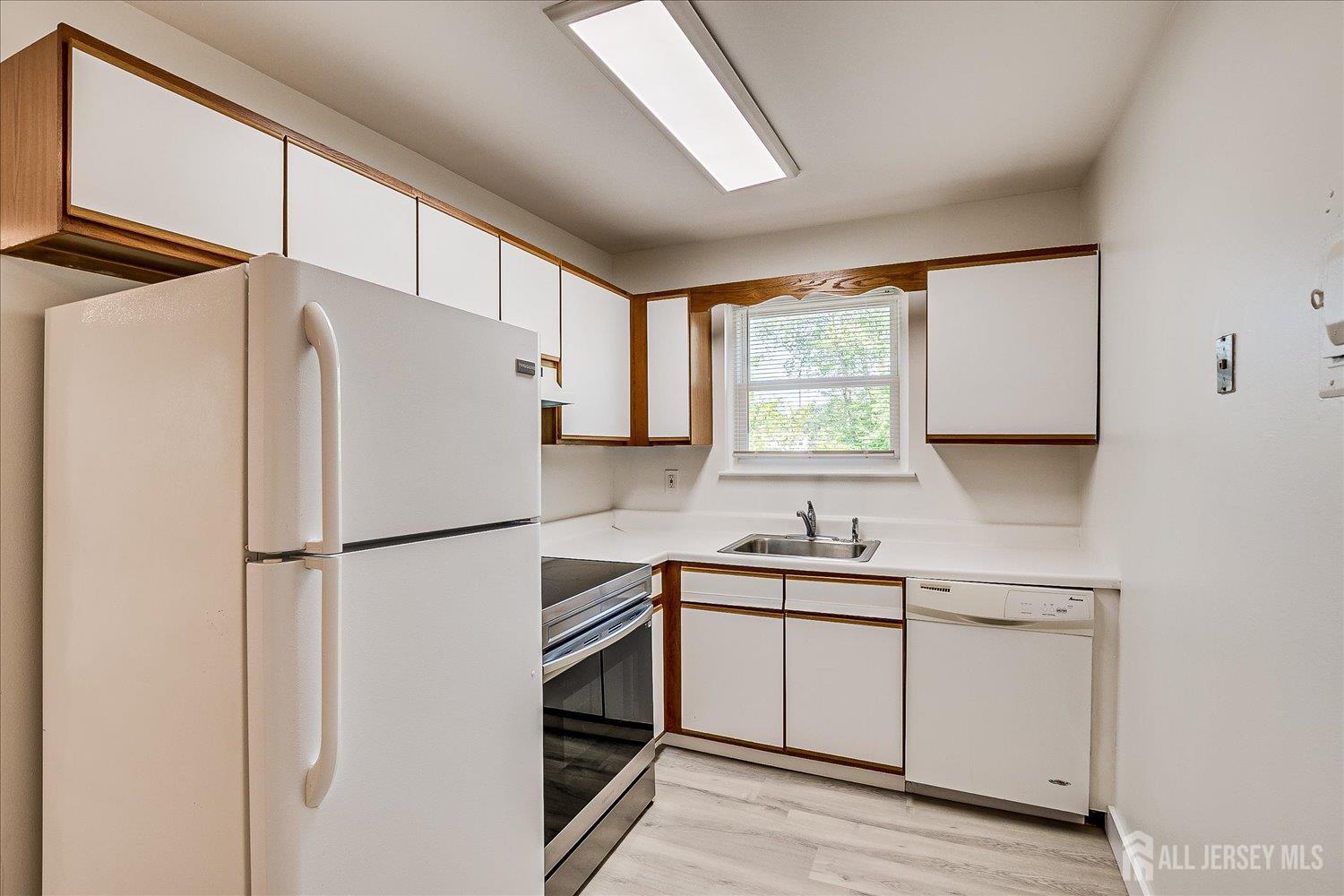 289 Main Street, Unit 4P Spotswood, NJ 08884 - Photo 12 of 22 a white refrigerator freezer sitting inside of a kitchen