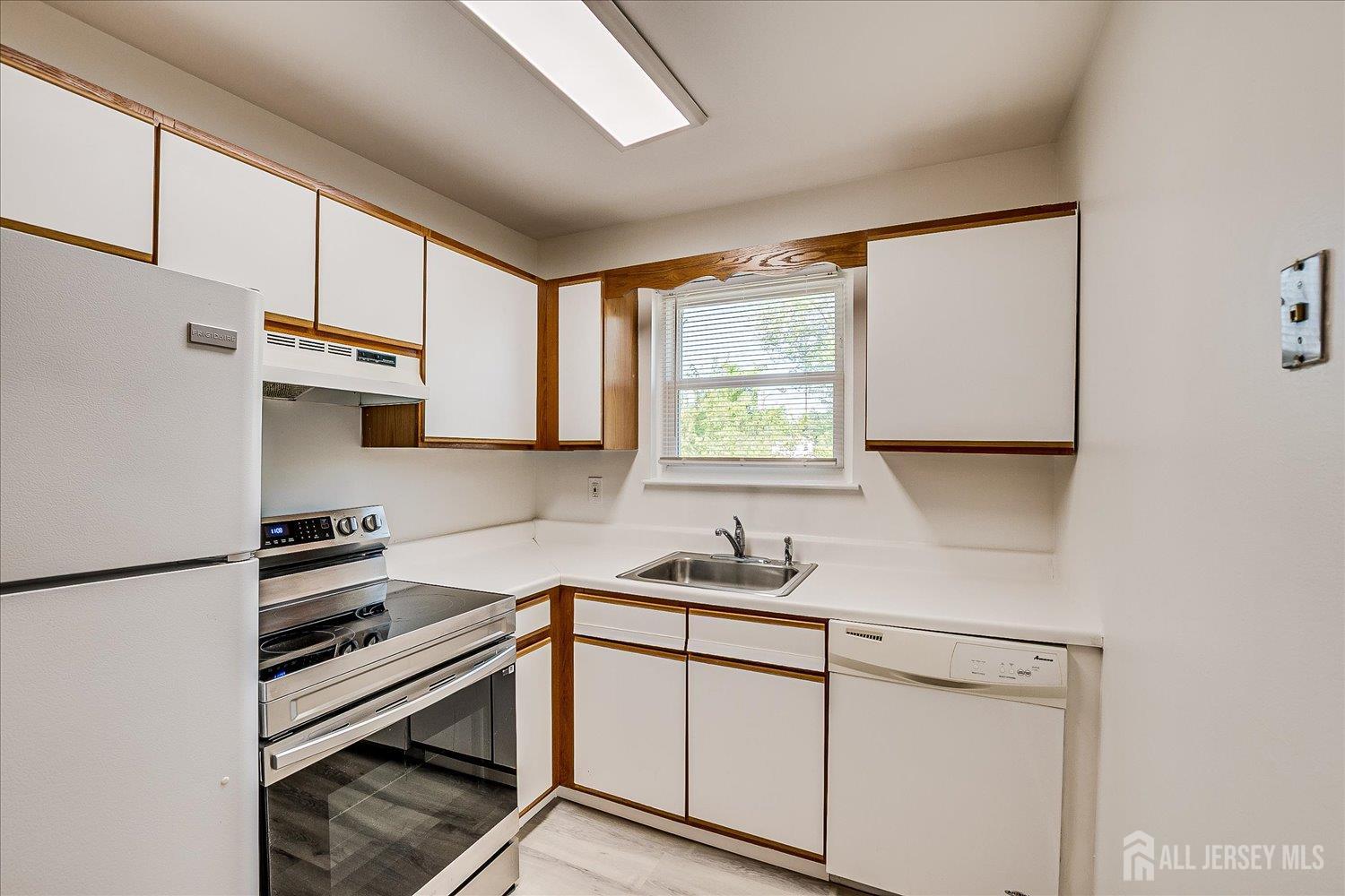 289 Main Street, Unit 4P Spotswood, NJ 08884 - Photo 13 of 22 a kitchen with a sink appliances cabinets and a window