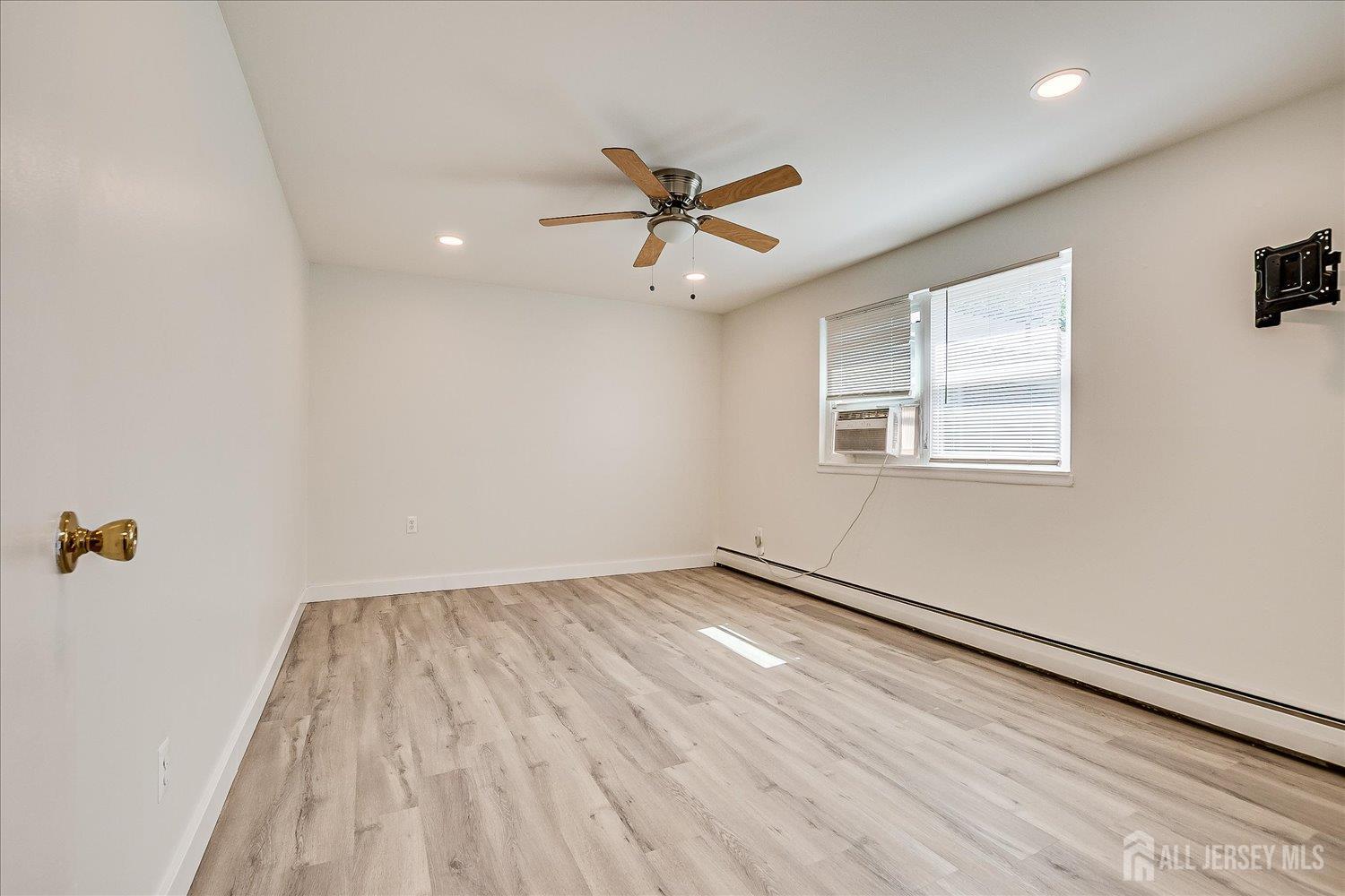 289 Main Street, Unit 4P Spotswood, NJ 08884 - Photo 15 of 22 wooden floor in an empty room with a window