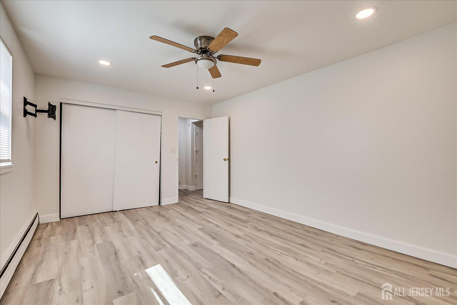 289 Main Street, Unit 4P Spotswood, NJ 08884 - Photo 16 of 22 a view of empty room with wooden floor and fan
