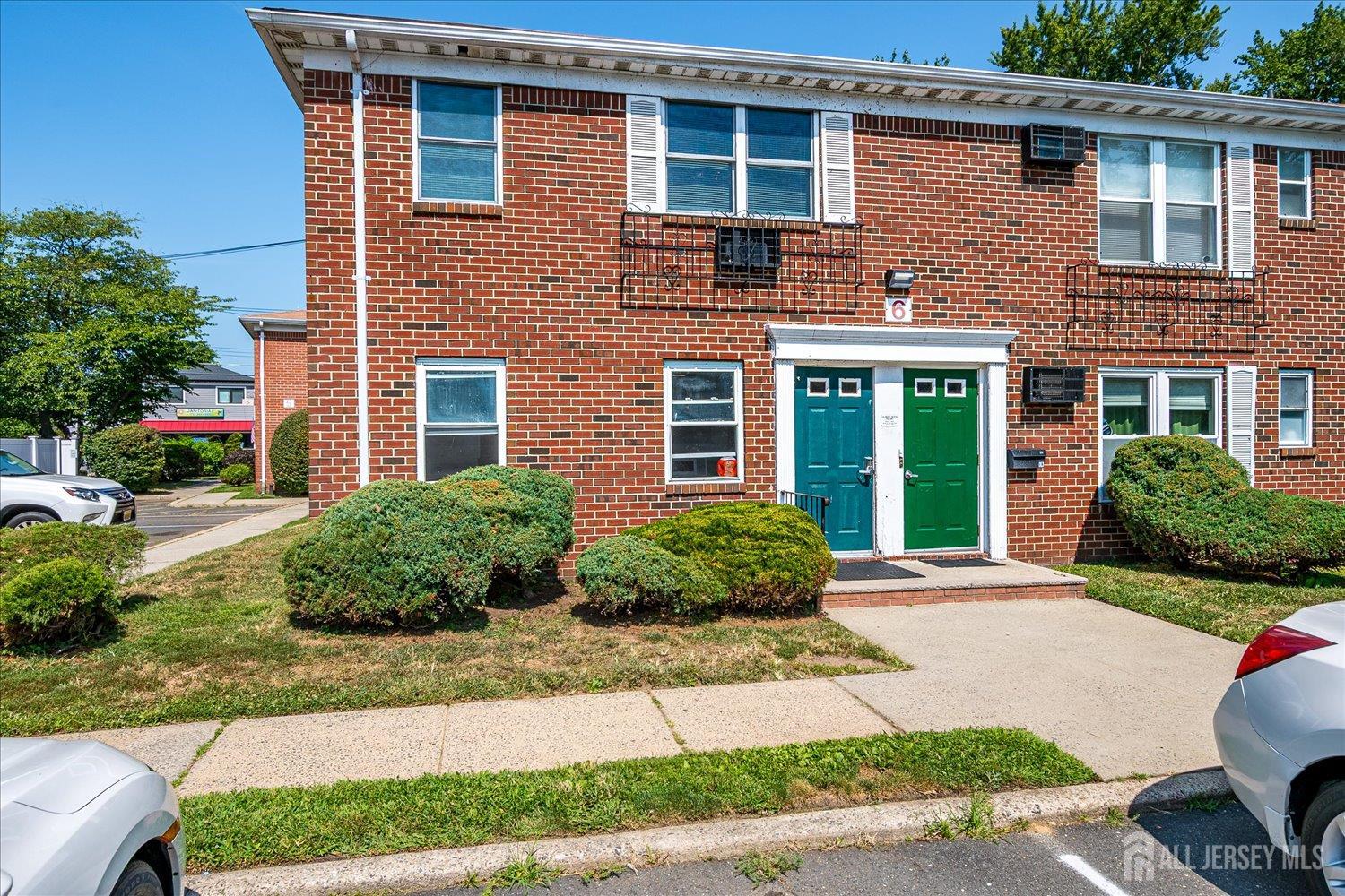 289 Main Street, Unit 4P Spotswood, NJ 08884 - Photo 18 of 22 a front view of a house with garden and plants