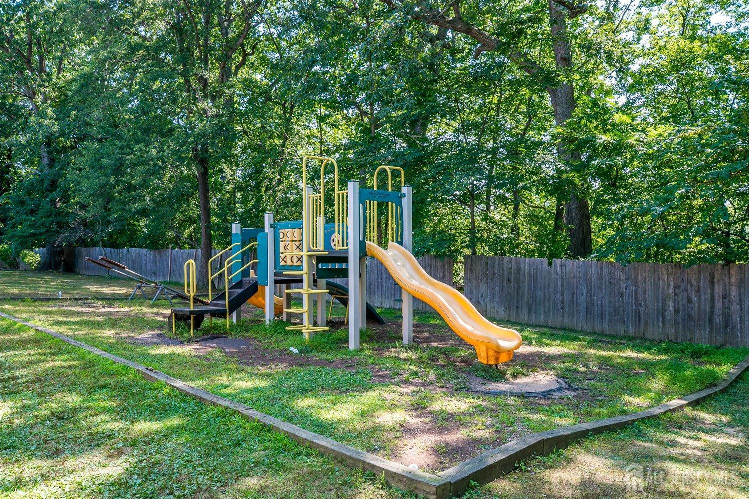 289 Main Street, Unit 4P Spotswood, NJ 08884 - Photo 22 of 22 a view of a backyard with a slide and wooden fence