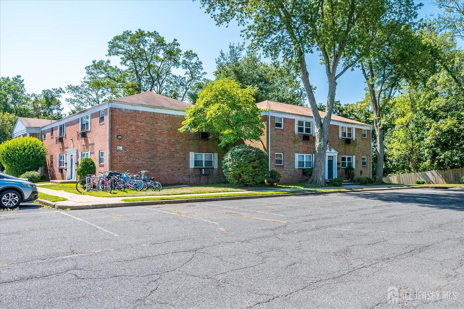289 Main Street, Unit 4P Spotswood, NJ 08884 - Photo 3 of 22 a front view of a house with a yard and trees