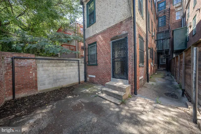 a view of a brick house with many windows next to road