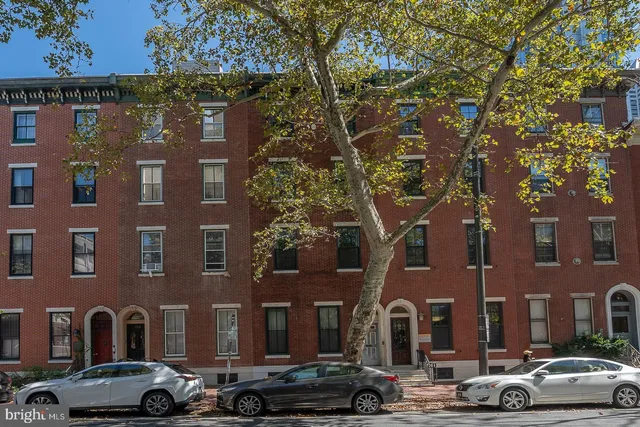 a couple of cars parked in front of brick building