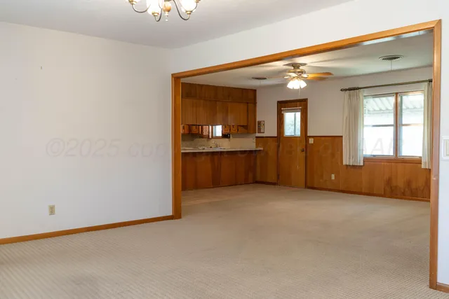 a view of an empty room with a kitchen