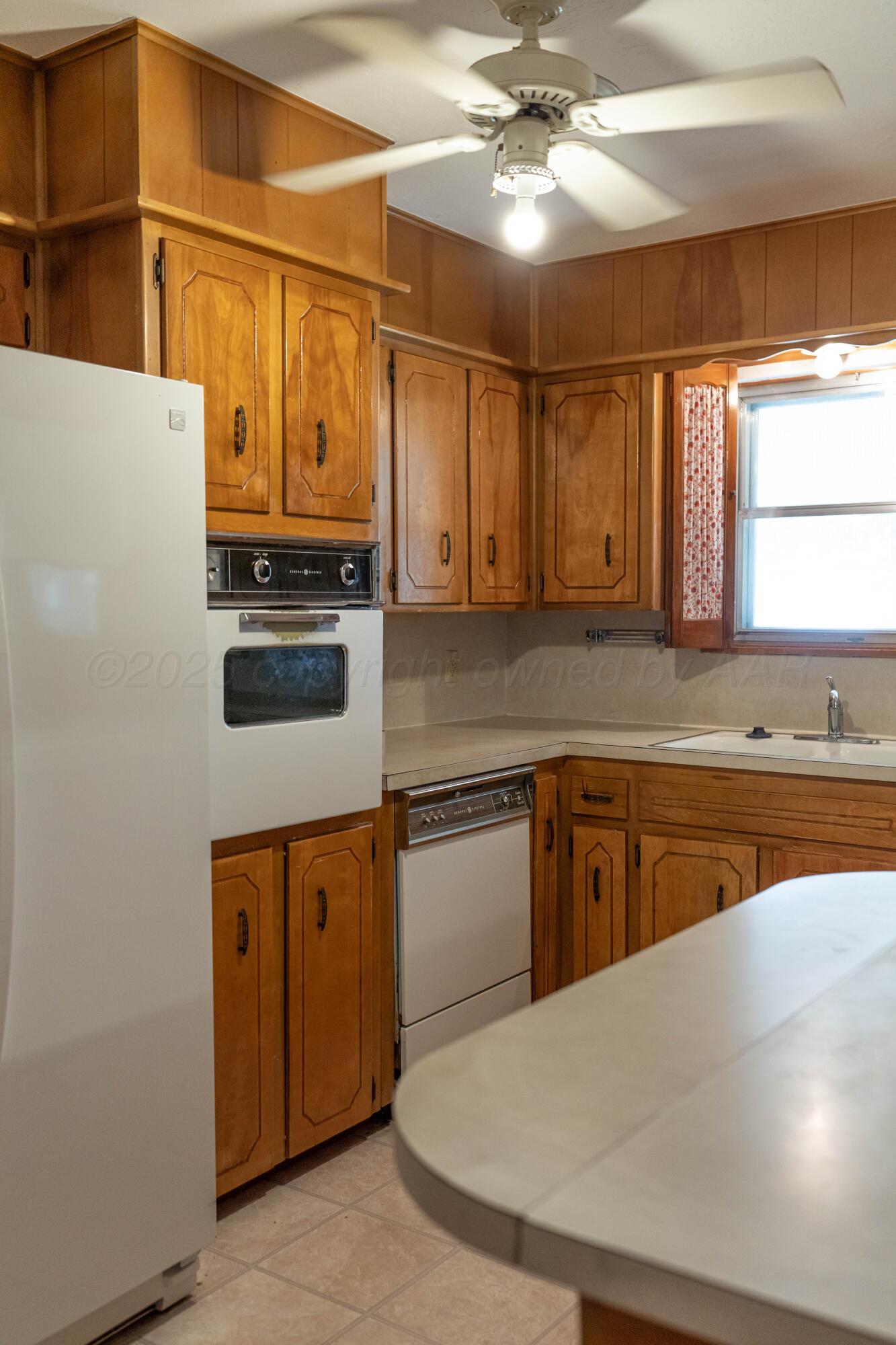 1315 South Canadian Street Wheeler, TX 79096 - Photo 19 of 44 a kitchen with stainless steel appliances granite countertop a sink a stove cabinets and wooden floor