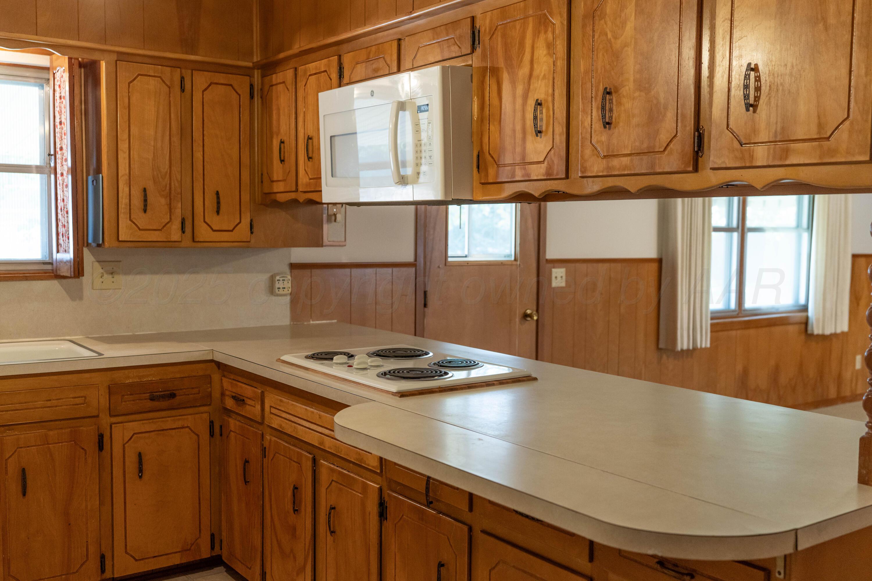 1315 South Canadian Street Wheeler, TX 79096 - Photo 20 of 44 a kitchen with stainless steel appliances granite countertop a sink a stove cabinets and wooden floor