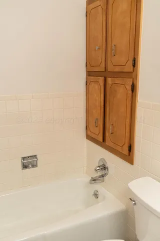 an empty room with a window and chandelier fan