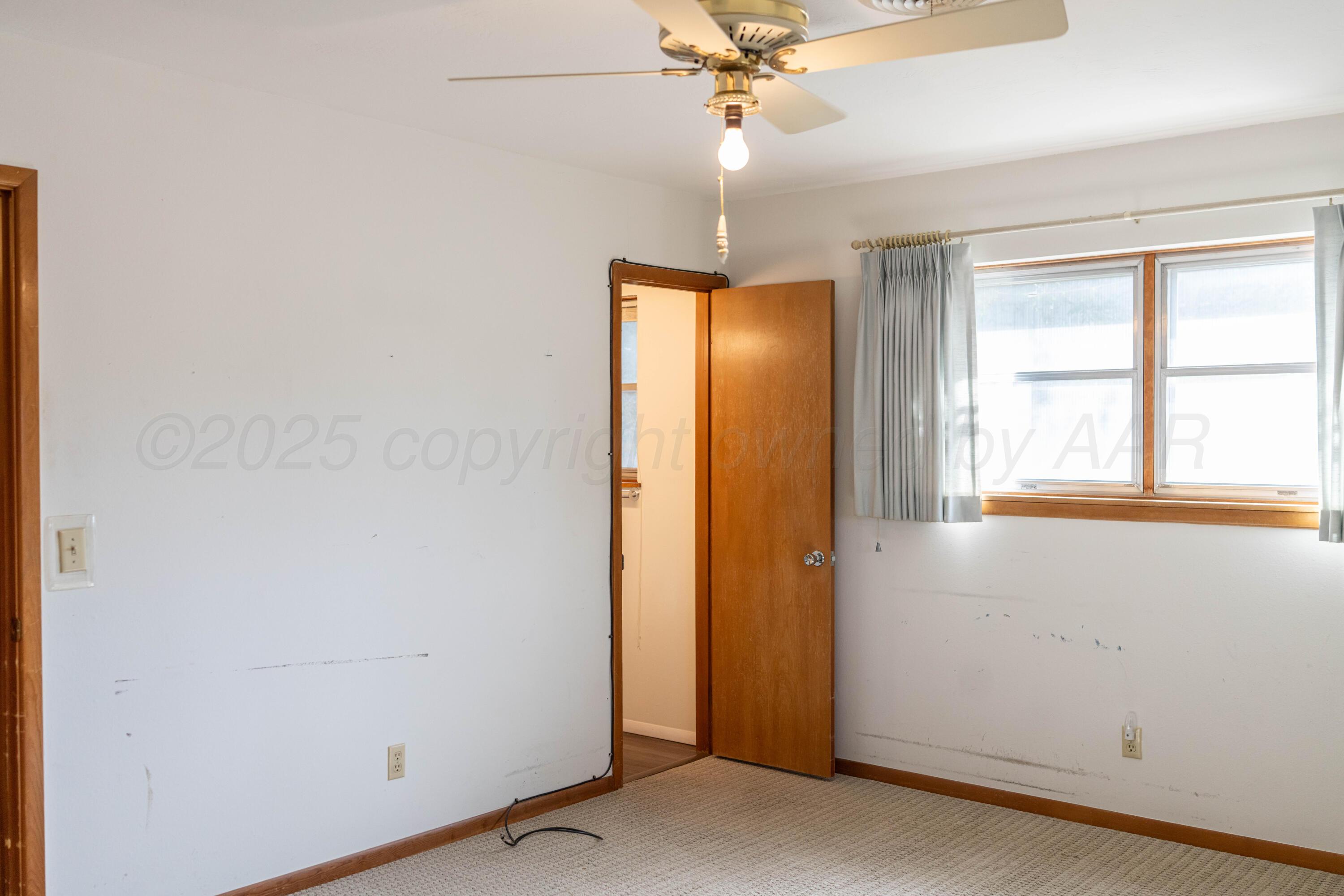 1315 South Canadian Street Wheeler, TX 79096 - Photo 38 of 44 an empty room with a window and chandelier fan