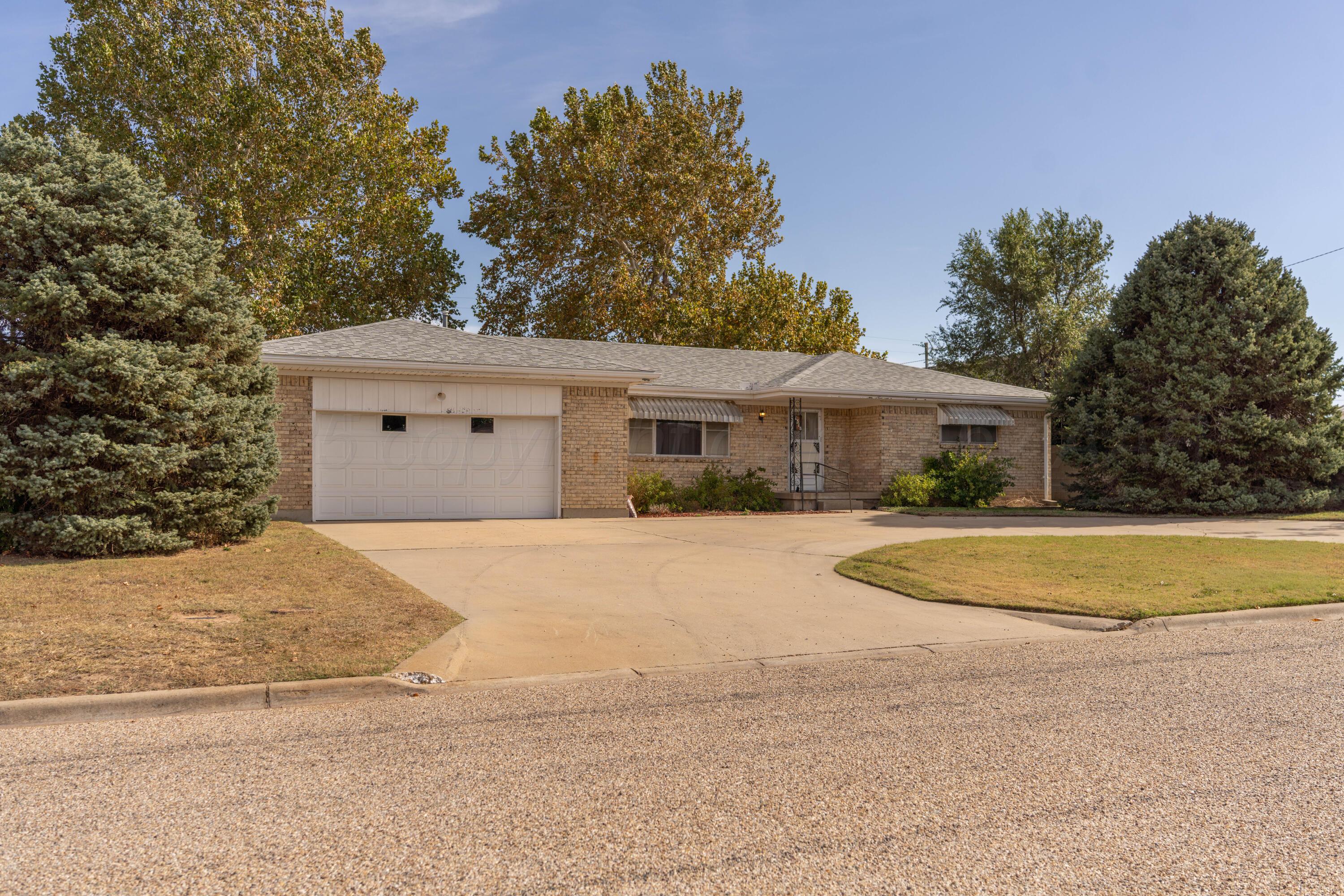 1315 South Canadian Street Wheeler, TX 79096 - Photo 4 of 44 a front view of a house with a yard and garage