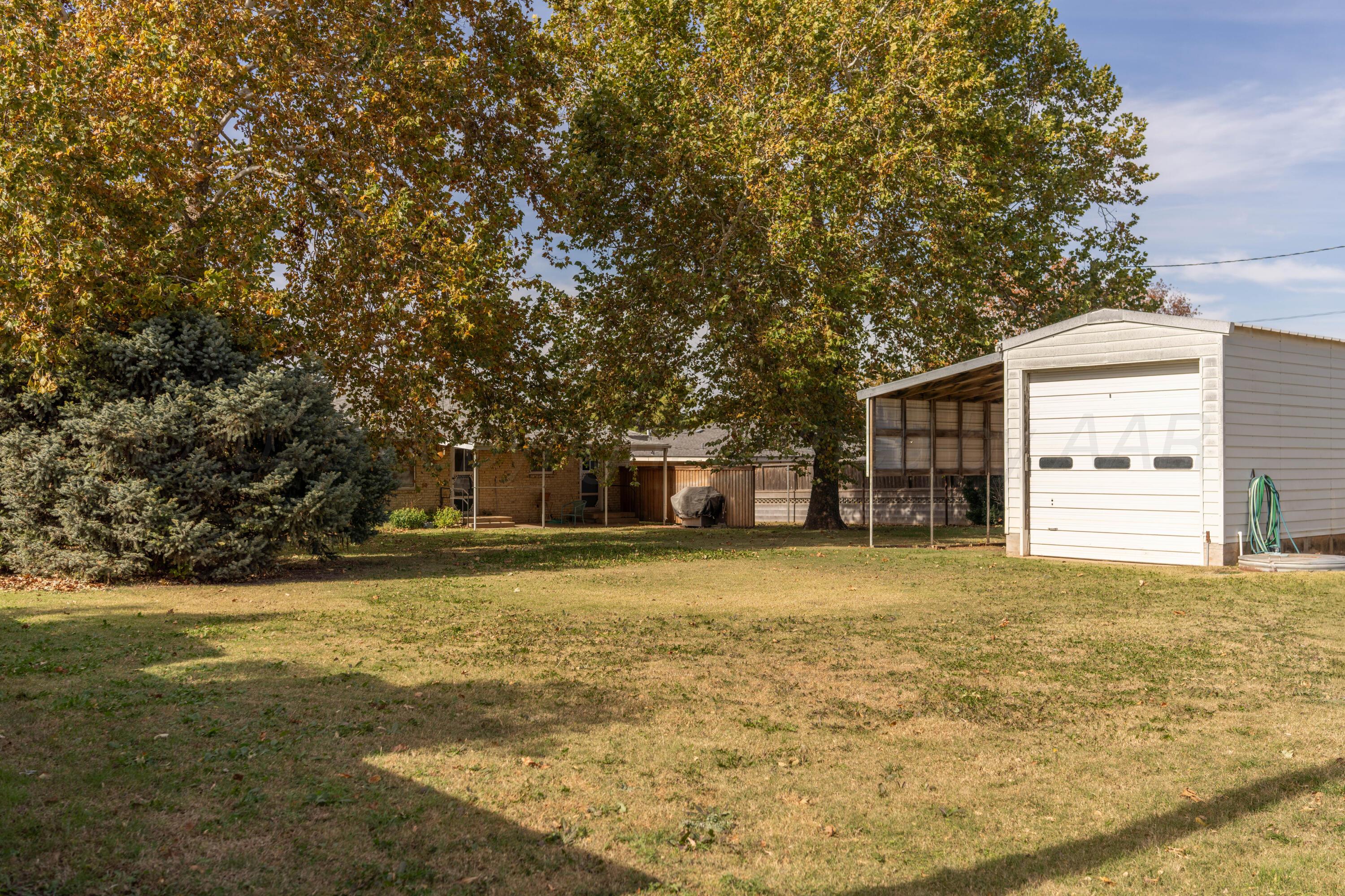 1315 South Canadian Street Wheeler, TX 79096 - Photo 7 of 44 a view of a house with a yard and garage
