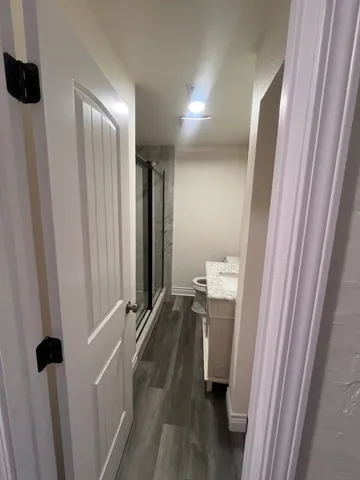 a view of a hallway with wooden floor and staircase