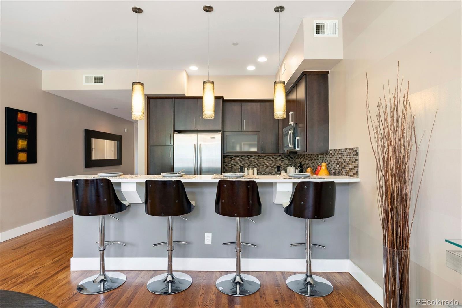 340 South Lafayette Street, Unit 102 Denver, CO 80209 - Photo 13 of 35 a kitchen with a refrigerator and chairs