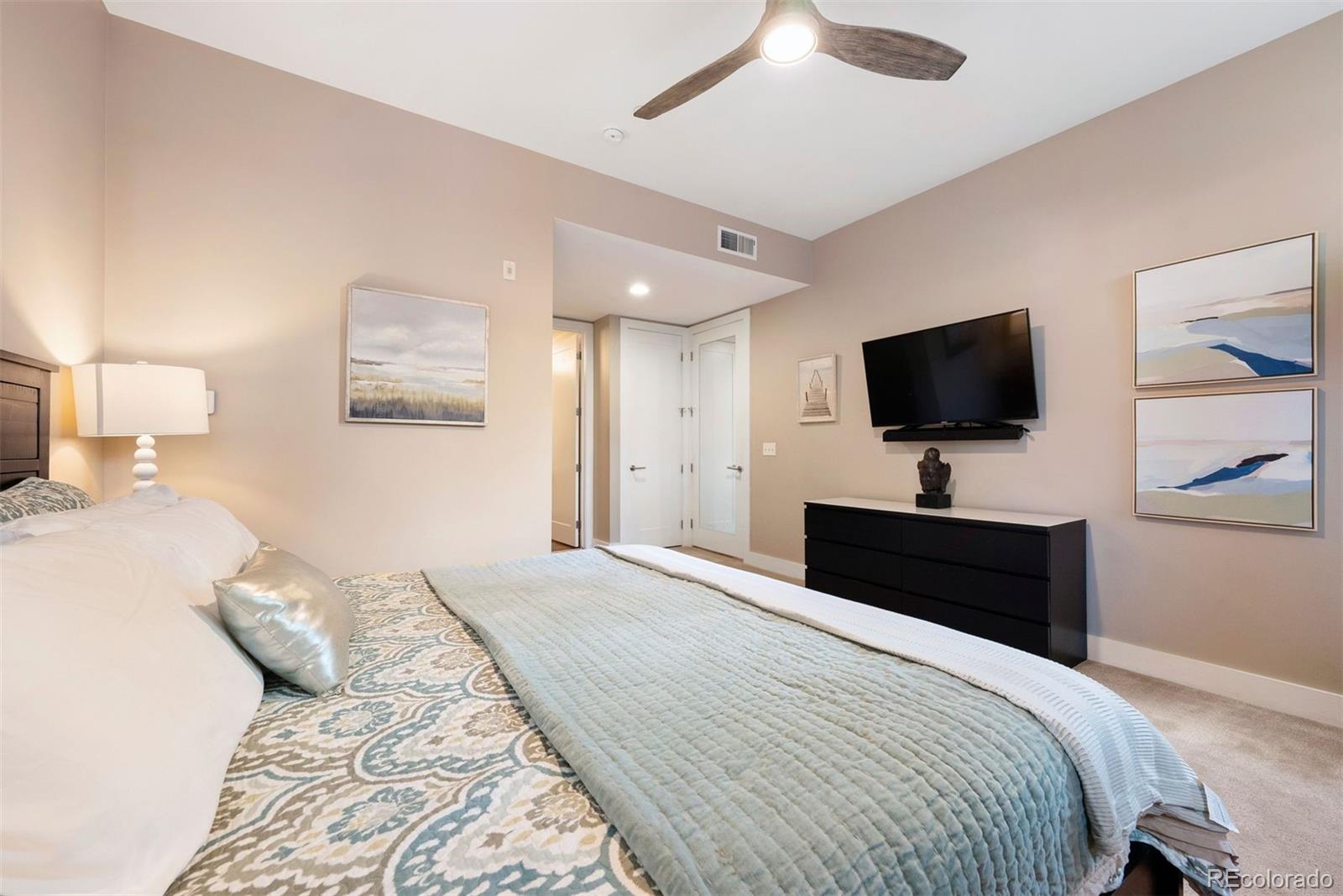 340 South Lafayette Street, Unit 102 Denver, CO 80209 - Photo 18 of 35 a bedroom with a bed tv and a chandelier