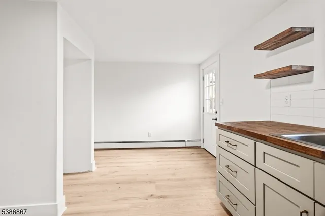 a kitchen with stainless steel appliances granite countertop white cabinets and window